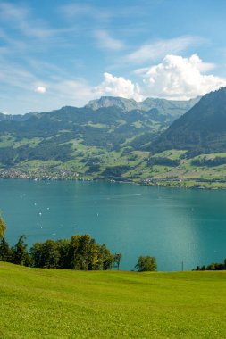 Manzaralı arka plan. İsviçre Alpleri ve göl manzarası. İsviçre manzarası. İsviçre dağları ve göl. Alpler 'deki yeşil çayır manzaralı güzel bir yer. Ulusal Park. Yürüyüş ve seyahat