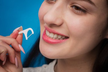 Diş geçmişi. Diş ve stomatoloji konsepti. Diş hijyeni ve ağız sağlığı konsepti. Diş ipiyle plastik kürdan kullanarak diş fırçalamak. Hijyen ve ağız boşluğu