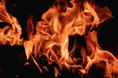 Siyah arka planda yangın. Yangın arka plan kıvılcımları. Soyut alevler arka planı. Yanan ateş. Siyah arkaplanda ateşin dokusu