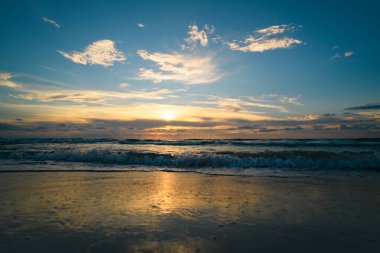 Okyanus dalgaları arka planı. Bulutlu arka planda gün doğumu. Akşamları deniz manzarası