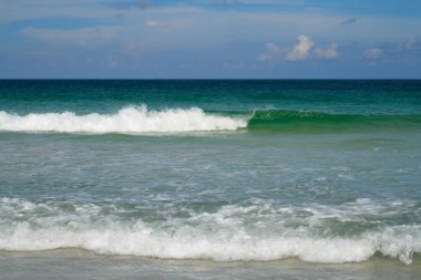 Okyanus dalgaları sıçrıyor. Okyanus dalgaları ve plaj arka planı. Okyanus ya da deniz dalgaları. Gökyüzü ve bulutlar arka plan. Dalga dokusu