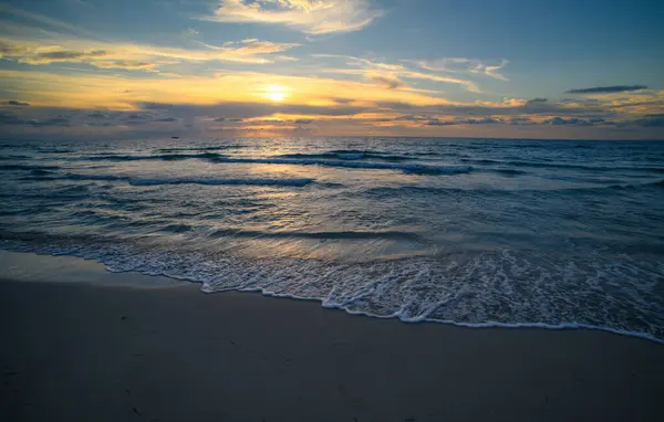 Bulutlu arka planda gün doğumu. Akşamları deniz manzarası. Okyanus dalgaları arka planı