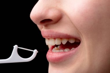 Diş sağlığı kliniği. Diş ve stomatoloji konsepti. Diş hijyeni ve ağız sağlığı konsepti. Diş ipiyle plastik kürdan kullanarak diş fırçalamak. Hijyen ve ağız boşluğu kavramı