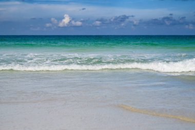 Sahilde dalgalar. Dalgalar arka plana sıçrıyor. Okyanus Dalgaları. Doğa için deniz manzarası. Gökyüzü ve bulutlar arka plan. Arkaplan veya arkaplan için deniz dalgaları