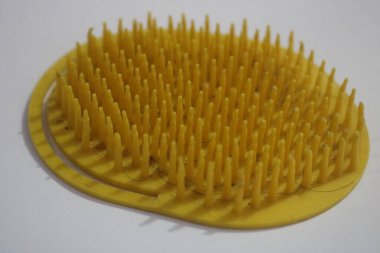 Siyah arka planda sarı bir tarağın yakın plan görüntüsü.