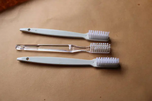 Beyaz masada farklı diş fırçaları var.