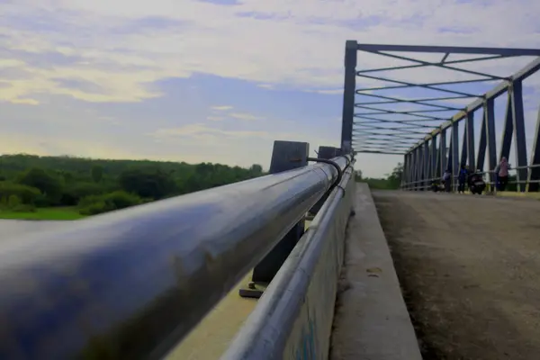 stock image construction of a steel bridge connecting the two regions. crossing a deep river. River water. green plant background