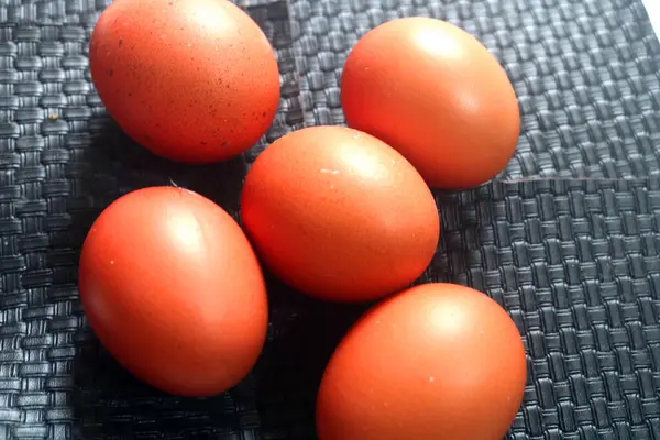 Ahşap arka planda kırmızı ve kahverengi yumurtalar. en üstteki görünüm