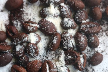 Bir fincan kahve, kahve çekirdekleri, çikolata ve tarçın çubukları.