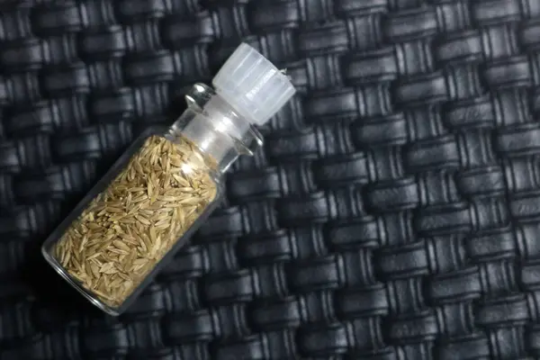 Esmer arka planda kenevir tohumlarıyla dolu kavanoz.