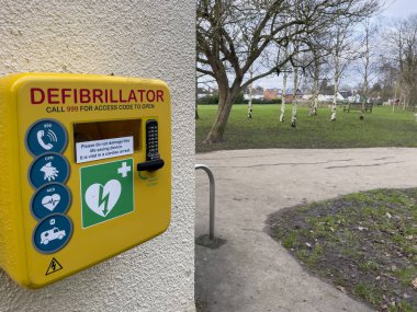 İlk yardım defibrilatörü Cheltenham, İngiltere 'de bir parkta duvara monte edildi. Acil kalp sorunu ya da canlandırma için kullanıma hazır.