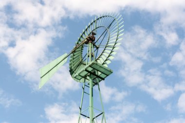 Mavi gökyüzünün önündeki yeşil rüzgar türbini