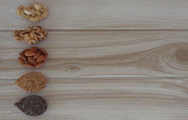 Tahta arka planda fındık ve fındık çeşitleri var.