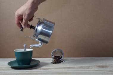 Bir fincan kahve ve gri arka planda bir kahve makinesi..