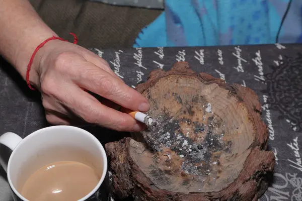 Kadın kahve içiyor ve fincanda kahve yapıyor.