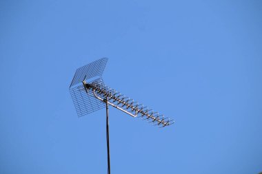 Mavi arka planda bir uydu anteninin düşük açılı görüntüsü.