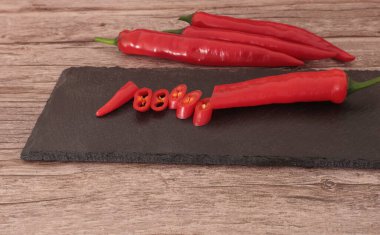 Ahşap arka planda tahtada yemek pişirmek için kırmızı biber ve tuz..