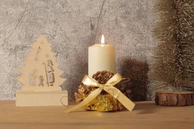 Noel süslemeleri ve ahşap masada köknar dallarıyla yanan mum.