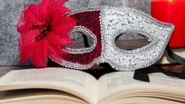 Tüyleri ve kırmızı süslemeleri olan siyah bir arka planda karnaval maskesi..