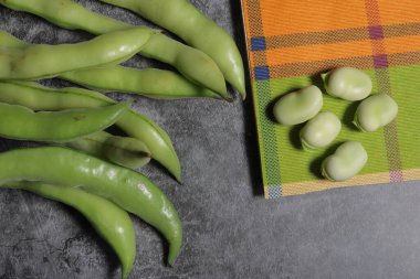 fresh green beans with a knife on a wooden table