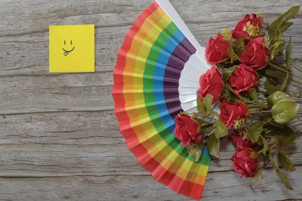 Renkli gökkuşağı buketi, kırmızı, sarı, turuncu, sarı ve kırmızı çiçekler ahşap arka planda.