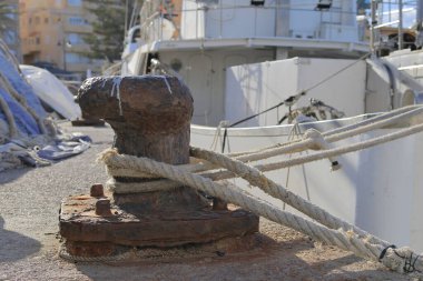 İskelede zinciri olan paslı bir çapa.