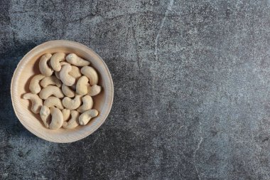 Gri desenli arka planda bir kase kaju fıstığı. yüksek kaliteli fotoğraf