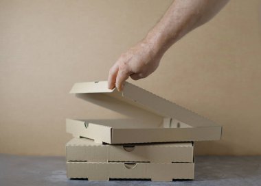 Erkek eli karton kutularla dolu karton bir kutu tutuyor.