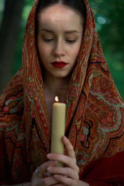    Mumlu kadın ormanda dua ediyor. 