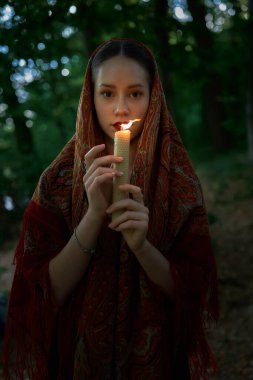    Mumlu kadın ormanda dua ediyor. 