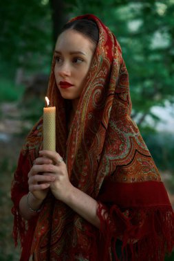    Mumlu kadın ormanda dua ediyor. 