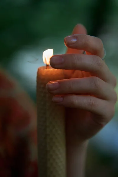 woman with candle prays in the forest