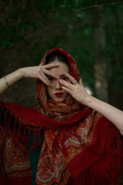 Slavic girl in a scarf pray in forest