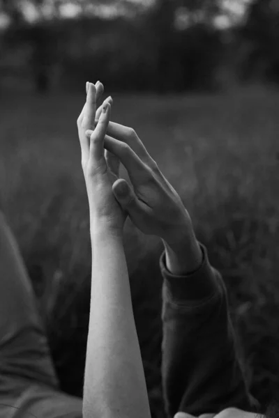 stock image young teen couple hold hands on a grass on a field in september                    