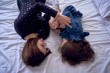       Anne ve kızı yatakta yatıyor.                         