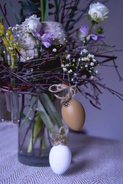          Paskalya çelengi, söğüt dalları yuvası ve şeffaf vazoda yumurta ve cam test tüpleriyle süslenmiş çiçekler.                      