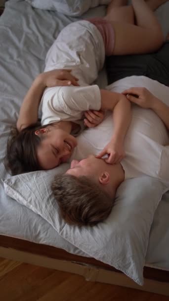 Genç Çift Yatakta Kız Erkeğin Omuzunda Sarılmalar Öpücükler Kahkahalar — Stok video