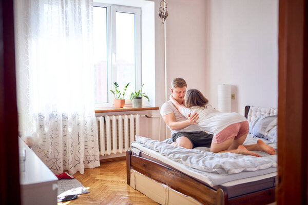 a young couple on the bed playing and fighting                    