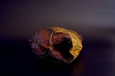 İştah açıcı sıcak tütsülenmiş siyah arka planda altın bir uskumru.