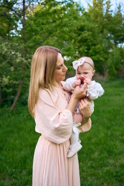  Küçük bir kız annesinin kollarında çilek yiyor.                 