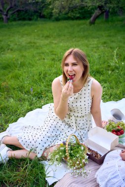         Anne ve genç kızı bahçede piknik yapıyorlar.                       