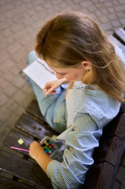  Genç ressam, şehrin sokaklarına bir pencere çiziyor.