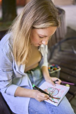  Genç ressam, şehrin sokaklarına bir pencere çiziyor.