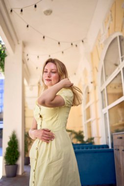 Sarı elbiseli güzel genç bir sanatçı poz verir.