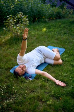  Adam sabahları bahçede somatik egzersizler yapıyor.