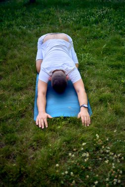  Adam sabahları bahçede somatik egzersizler yapıyor.