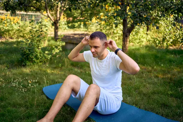 stock image  man performs somatic exercises in the garden in the morning