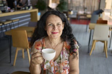           60 'lı yılların kadını öğle arasında modern iş yerinde ısırgan otu çayı içiyor.                                                 