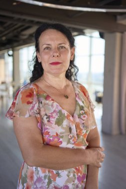 Çağdaş ofis çalışma alanında 60 'lı yılların çiçekçi elbiseli iş kadını.