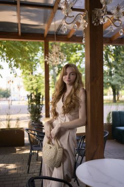            Güzel genç kız, şeftali tüyü takım elbiseli, yelekli, eski para tarzında şık bir restoranda.                                       